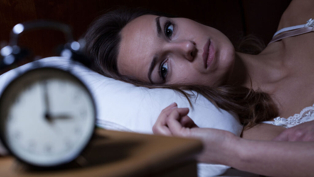 Woman in bed struggling with insomnia