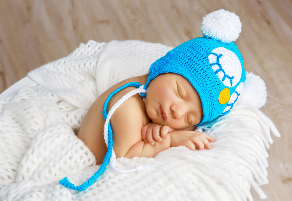 newborn baby sleeping in blue hat