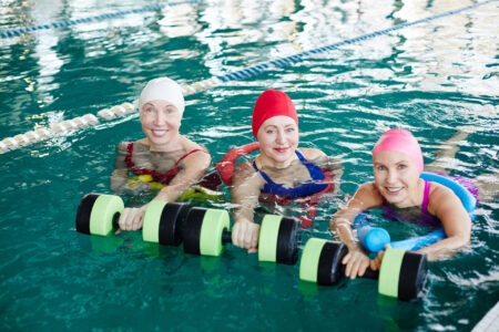 three senior woman in a pool doing water aerobics