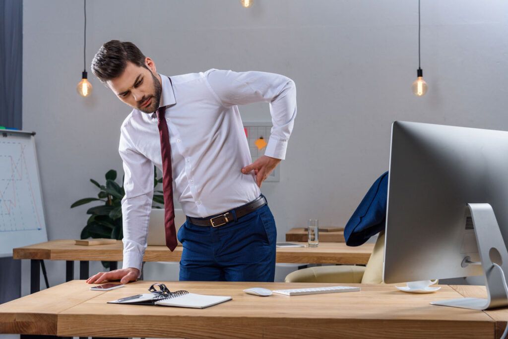 businessman having low back pain in his office