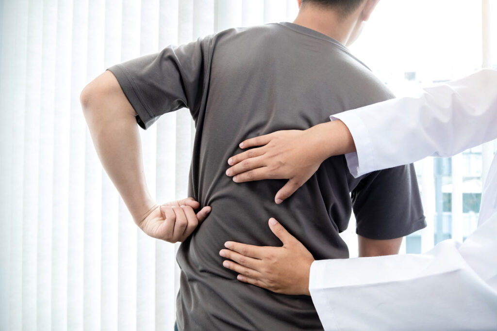doctor examining patient with low back pain