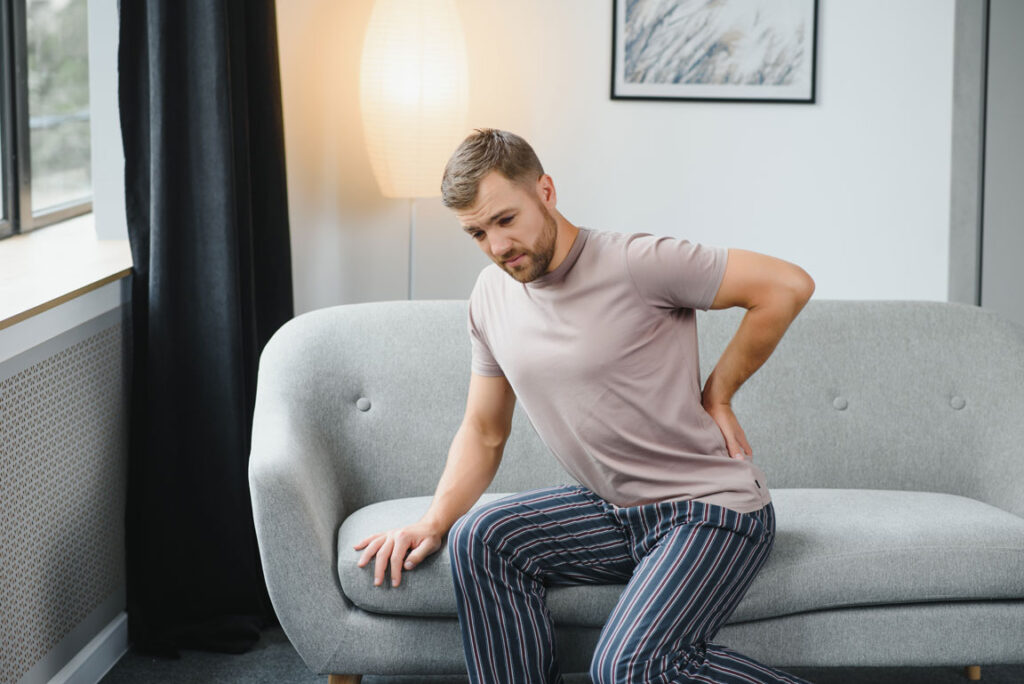 man with herniated disc sitting on couch