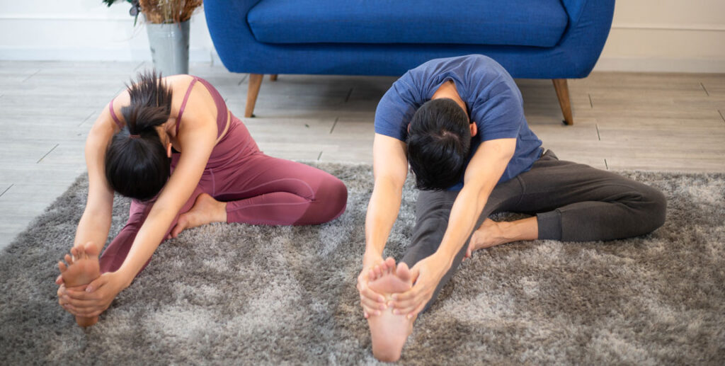young couple stretching at home