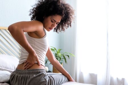rear-view-of-woman-touching-lumbar-feeling-back-pa-2023-11-27-05-00-45-utc (1) Woman touching lumbar