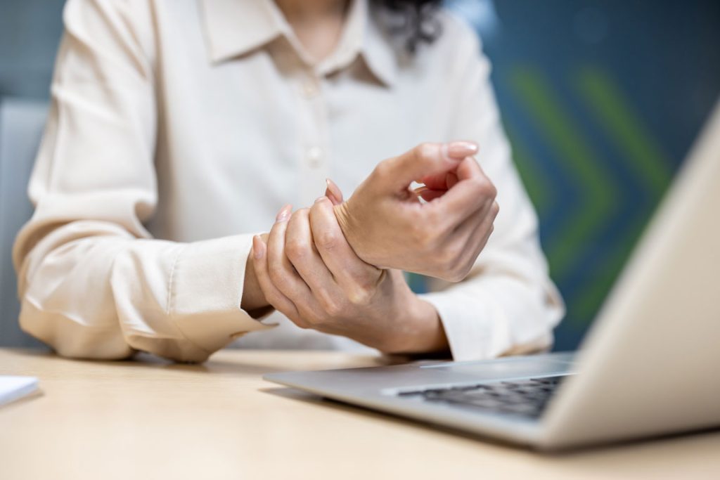 woman-in-office-experiences-wrist-pain carpal tunnel syndrome