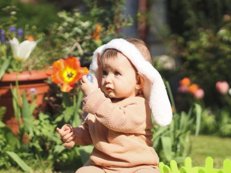 baby in spring yard wearing bunny ears