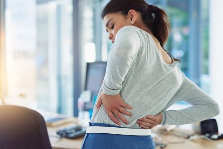 woman experiencing back pain in the office