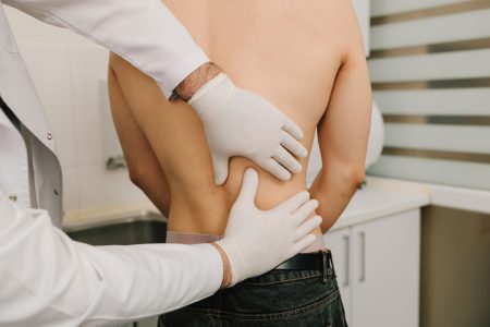 healthcare professional examining patient's back
